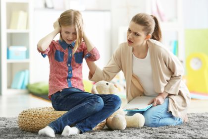 girl covering ears refusing to mum asking her to go to school