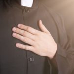 Priest places hand on heart