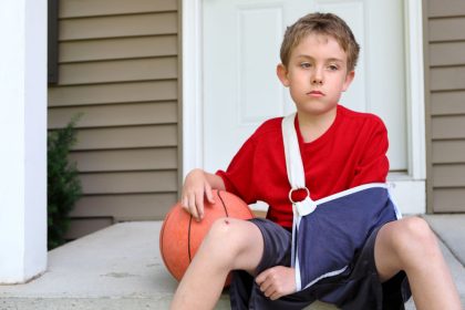 Boy sits on step with arm injury