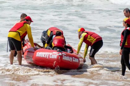 Surf lifesavers get into a boat at the beach