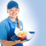 Fast food worker in uniform holds a bowl of chips